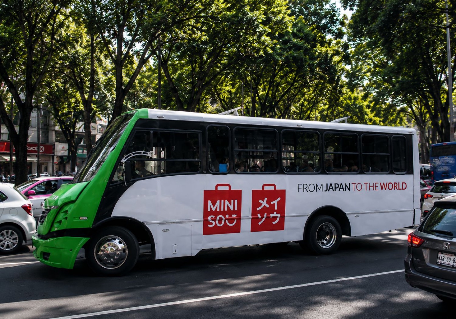 Wrap lateral integral de Miniso en autobús urbano — publicidad exterior OOH en México con BusBus